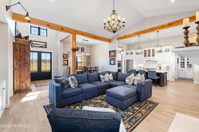 living area featuring light wood finished floors, high vaulted ceiling, recessed lighting, french doors, and a chandelier