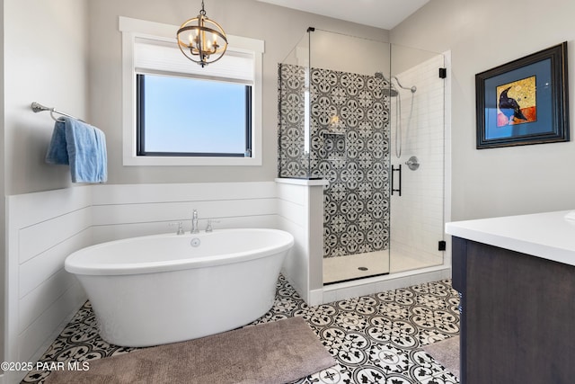 bathroom with vanity, a soaking tub, a stall shower, tile patterned floors, and a chandelier