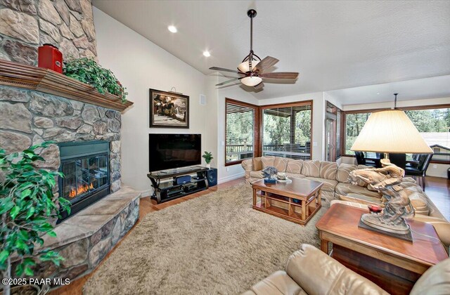 2140 Lone Oak Way, Prescott, AZ 86305 - living area featuring a stone fireplace, a ceiling fan, lofted ceiling, wood finished floors, and recessed lighting
