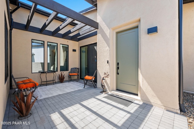 5692 E Cannon Pl, Prescott Valley, AZ 86314 - view of exterior entry featuring stucco siding, a pergola, and a patio area