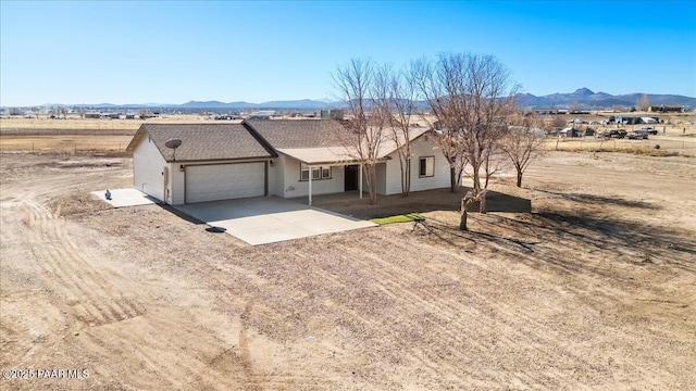 ranch-style house with a garage and a mountain view