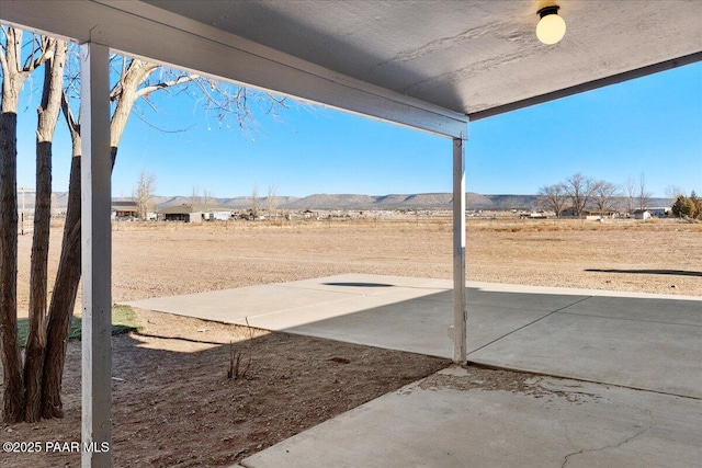 view of yard featuring a patio area and a mountain view