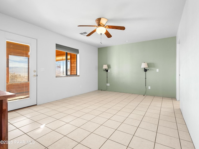 tiled empty room featuring ceiling fan