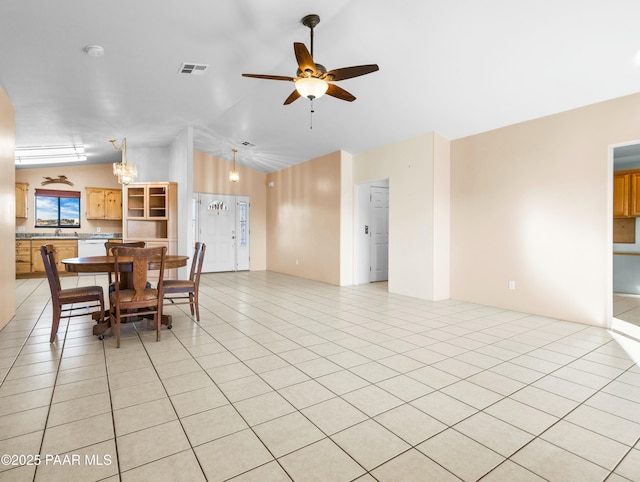 dining area featuring ceiling fan, light tile patterned floors, and vaulted ceiling