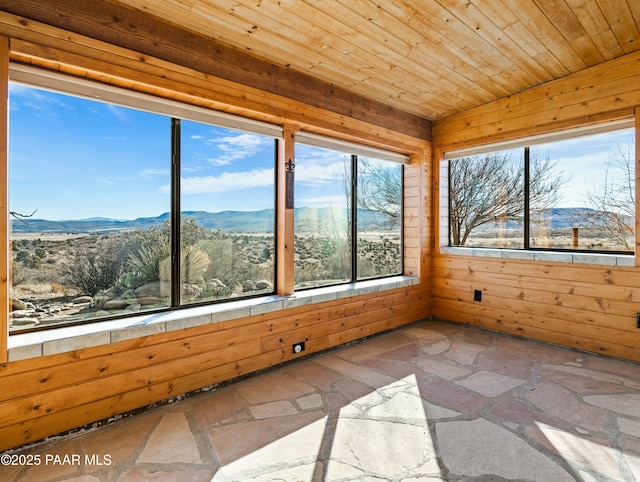 unfurnished sunroom featuring a mountain view and wooden ceiling