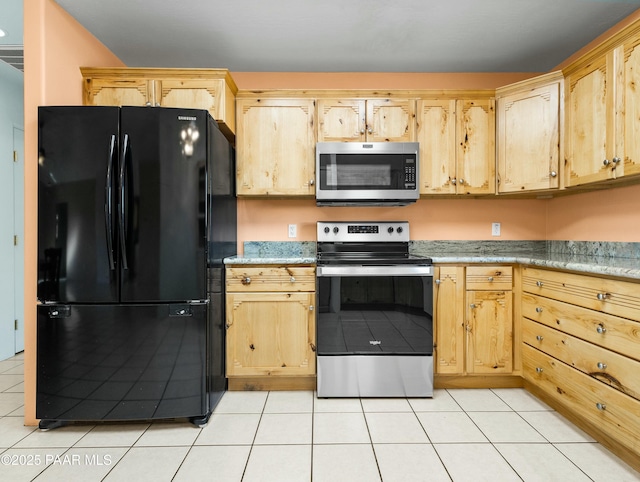 kitchen with light tile patterned flooring, appliances with stainless steel finishes, and light brown cabinets