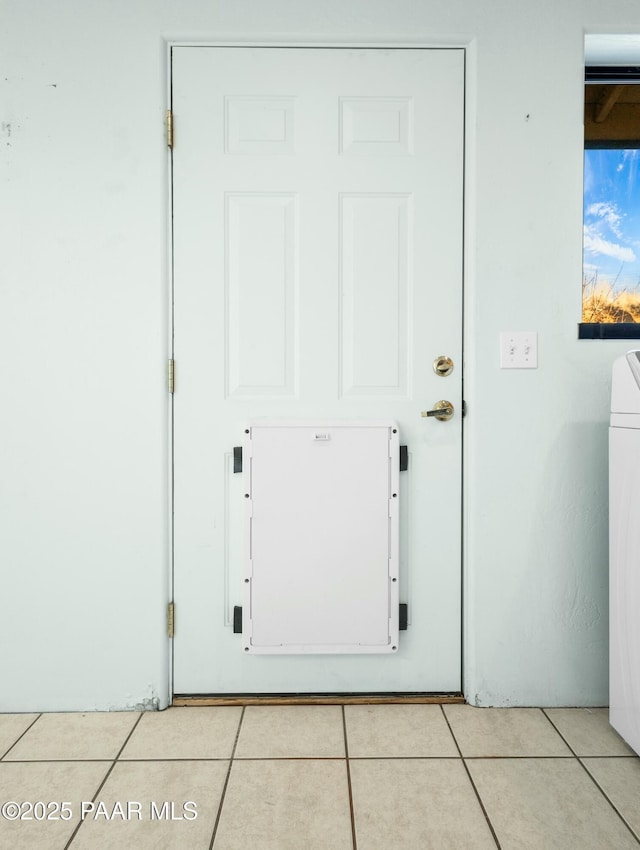 doorway to outside featuring light tile patterned floors and washer / clothes dryer