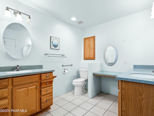 bathroom with toilet, vanity, and tile patterned flooring