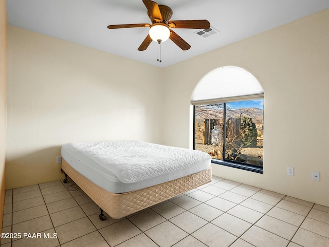 tiled bedroom with ceiling fan