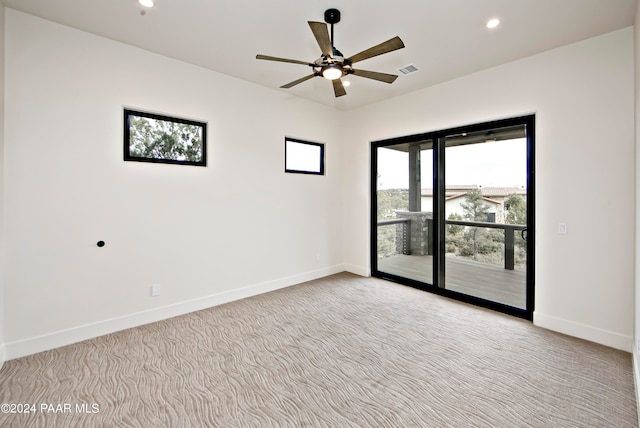 spare room with ceiling fan and light colored carpet