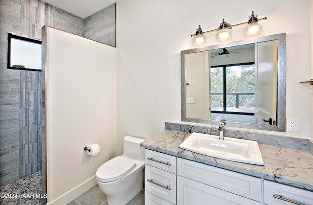 bathroom featuring a tile shower, ceiling fan, tile patterned floors, toilet, and vanity