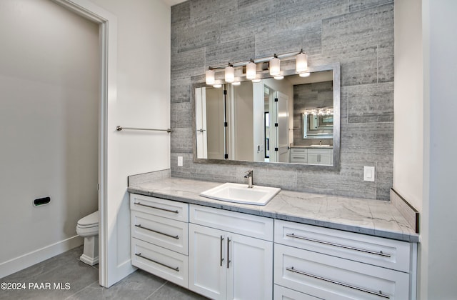 bathroom featuring tile patterned flooring, vanity, and toilet