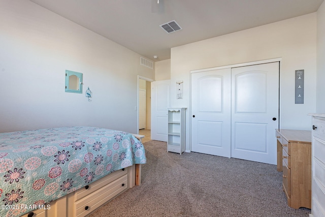 bedroom with ceiling fan, dark carpet, and a closet