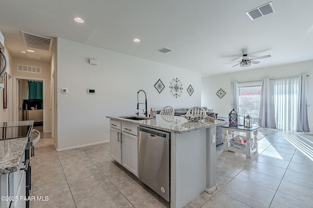 kitchen with dishwasher, sink, an island with sink, white cabinets, and light stone counters