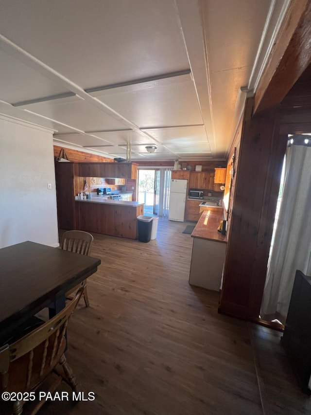 dining area with dark wood-style floors and wooden walls