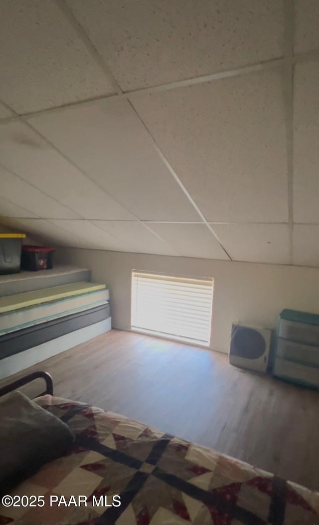 interior space with a drop ceiling, visible vents, and wood finished floors