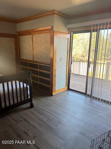 bedroom with crown molding, access to outside, and wood finished floors