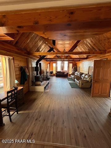 interior space featuring wood ceiling, wooden walls, vaulted ceiling with beams, and wood finished floors