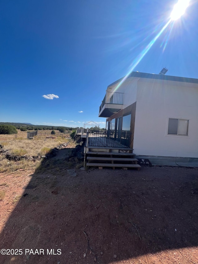 view of property exterior with a balcony and a deck