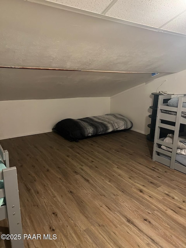 bedroom featuring wood finished floors and vaulted ceiling