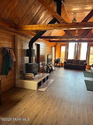 living room with a wood stove, wood finished floors, and wood walls