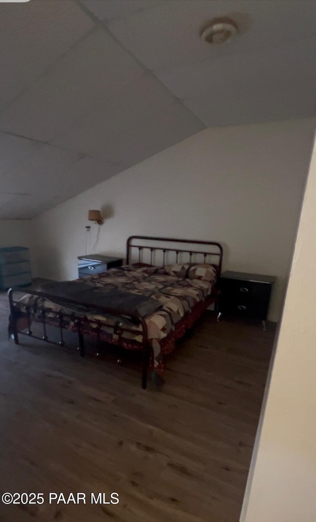 bedroom featuring lofted ceiling and wood finished floors