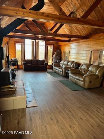 living area featuring wood ceiling, wood finished floors, vaulted ceiling with beams, and wood walls