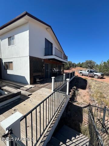 view of side of home featuring a balcony and fence