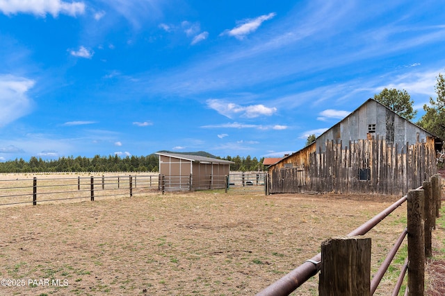 8222 N Spring Valley Rd, Parks, AZ 86018 - view of yard with an outdoor structure, a rural view, an outbuilding, fence, and an exterior structure