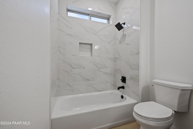 bathroom with tiled shower / bath combo and toilet