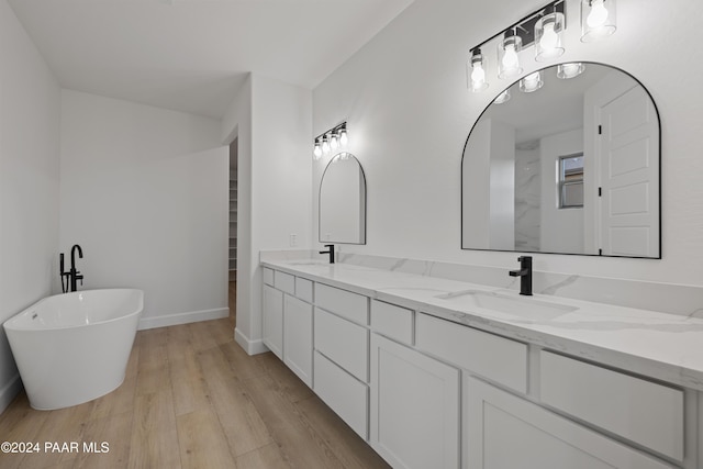 bathroom with hardwood / wood-style floors, vanity, and a washtub