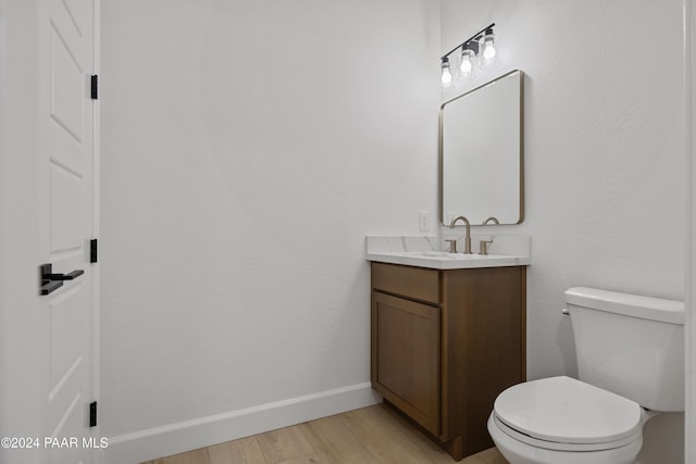 bathroom featuring hardwood / wood-style floors, vanity, and toilet