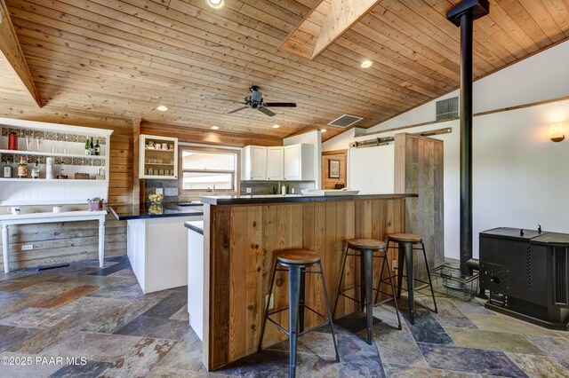 1135 N Rose Quartz Dr, Prescott, AZ 86303 - kitchen with dark countertops, stone tile floors, vaulted ceiling, wooden ceiling, and white cabinetry