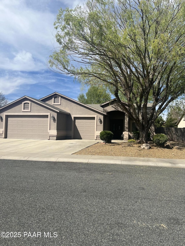 5626 N Ardmore Ave, Prescott Valley, AZ 86315 - view of front of property with an attached garage, fence, driveway, and stucco siding