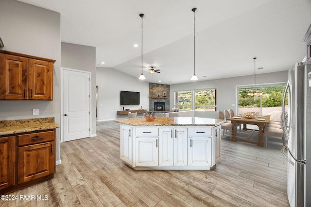 kitchen featuring stainless steel refrigerator, ceiling fan, hanging light fixtures, lofted ceiling, and light wood-type flooring