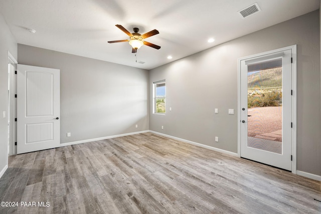 spare room featuring ceiling fan, plenty of natural light, and light hardwood / wood-style flooring