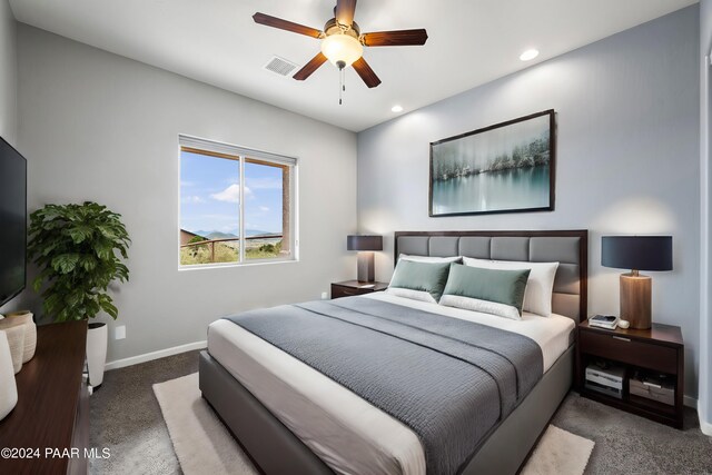 bedroom featuring ceiling fan and dark carpet