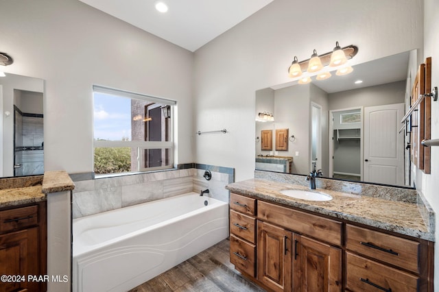 bathroom featuring hardwood / wood-style floors, a bathtub, and vanity