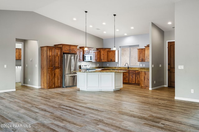 kitchen with a center island, high vaulted ceiling, light wood-type flooring, decorative light fixtures, and stainless steel appliances