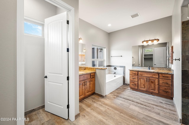 bathroom featuring hardwood / wood-style flooring, vanity, and a bathing tub