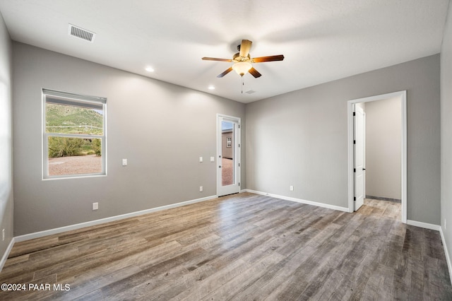 spare room with ceiling fan and light wood-type flooring