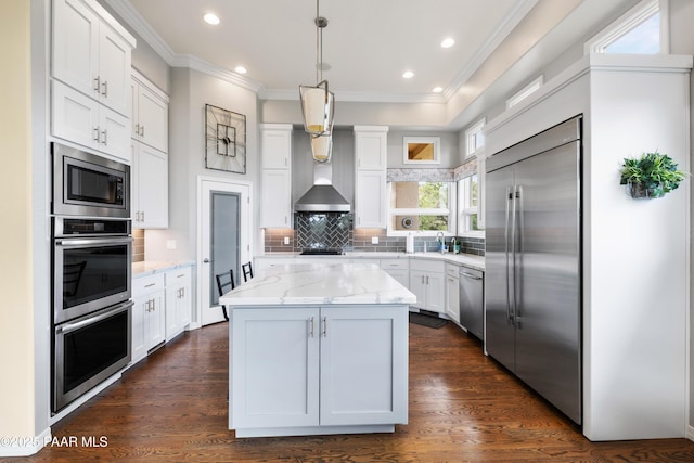 kitchen featuring dark wood finished floors, white cabinetry, built in appliances, and light stone counters