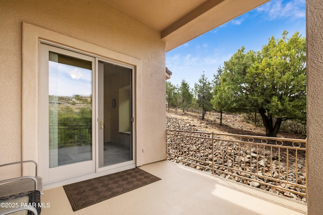 doorway to property with a balcony and stucco siding