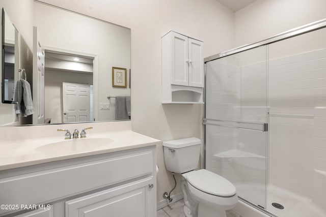 full bath featuring a stall shower, baseboards, toilet, and vanity