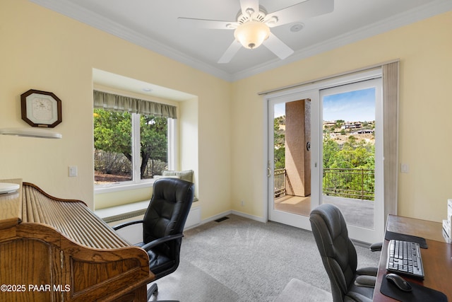 carpeted home office featuring baseboards, visible vents, crown molding, and ceiling fan