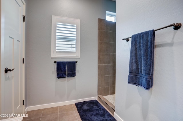 bathroom with tile patterned flooring and a tile shower