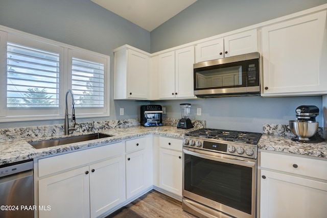 kitchen featuring white cabinets, light stone countertops, sink, and appliances with stainless steel finishes