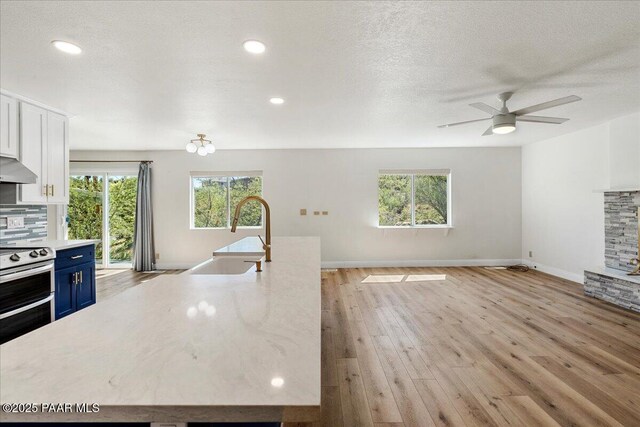 902 Fern Dr, Prescott, AZ 86305 - kitchen featuring blue cabinetry, a sink, light countertops, healthy amount of natural light, and a textured ceiling