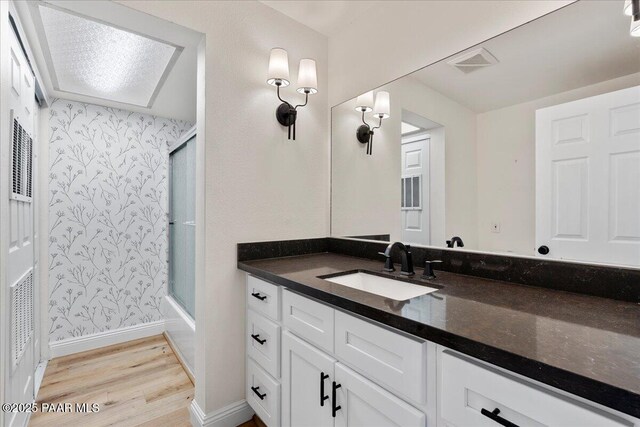 902 Fern Dr, Prescott, AZ 86305 - full bath with wood finished floors, baseboards, vanity, wallpapered walls, and shower / bath combination with glass door