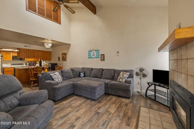 217 Creekside Cir Unit 16G, Prescott, AZ 86303 - living room featuring wood finished floors, ceiling fan, beamed ceiling, and a high ceiling